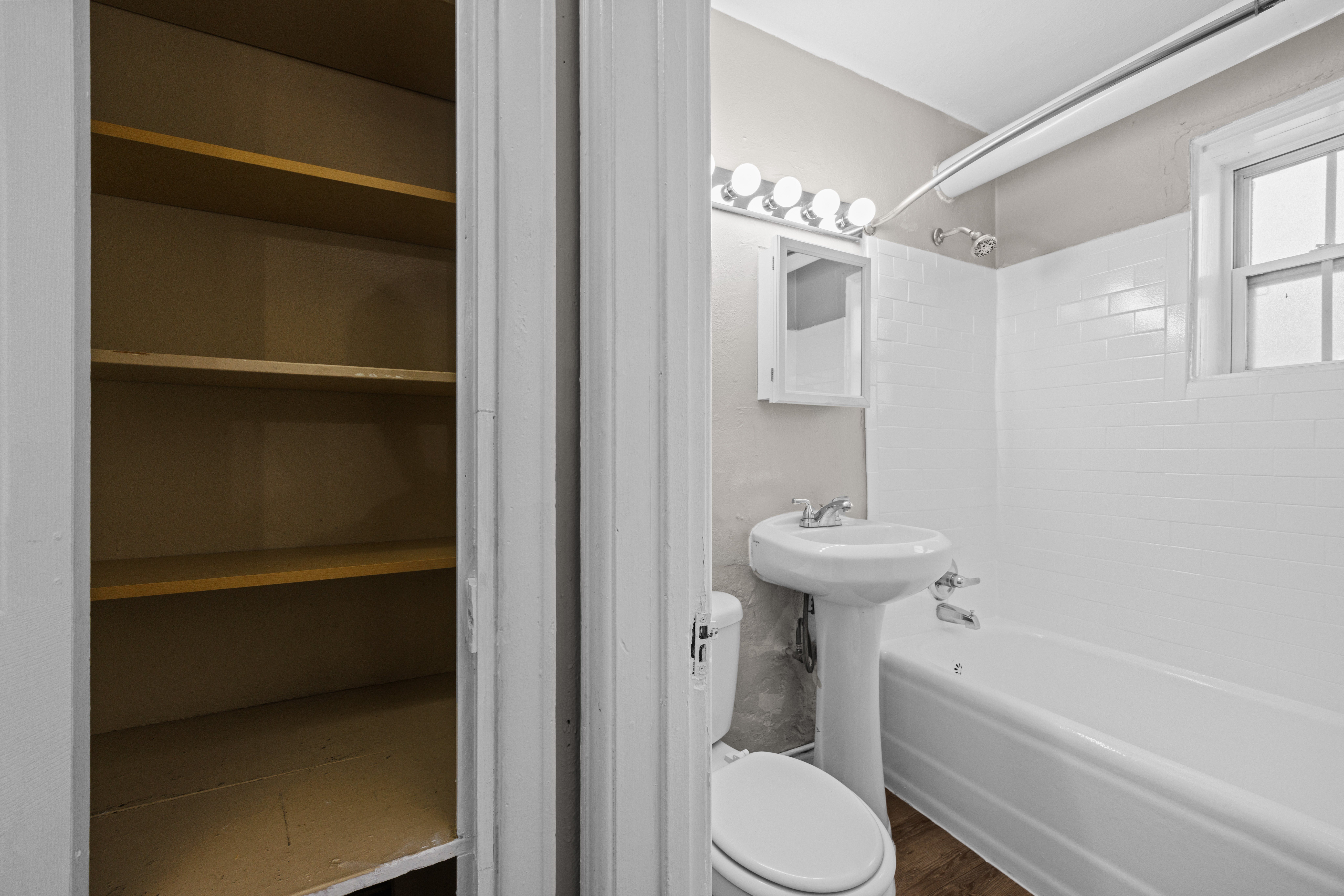 A white bathroom with a toilet, sink, and a bathtub.